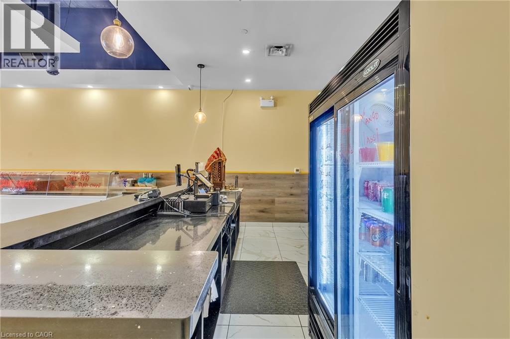Commercial-grade beverage display cooler with two glass doors, set against a light beige wall and wood-finish paneling - 5 Manitou Drive Unit# 106B, Kitchener, ON