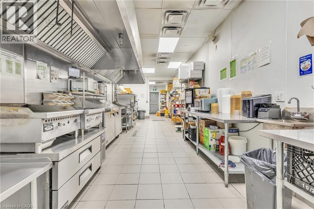 Commercial kitchen featuring stainless steel appliances and extensive counter space - 5 Manitou Drive Unit# 106B, Kitchener, ON