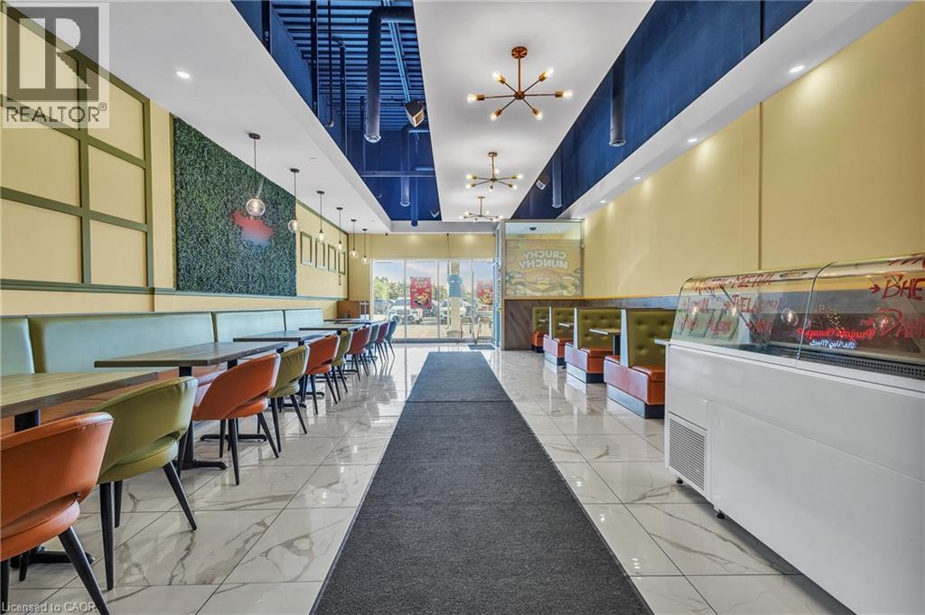 Contemporary interior featuring white marble-look flooring and a recessed ceiling with exposed ductwork - 5 Manitou Drive Unit# 106B, Kitchener, ON