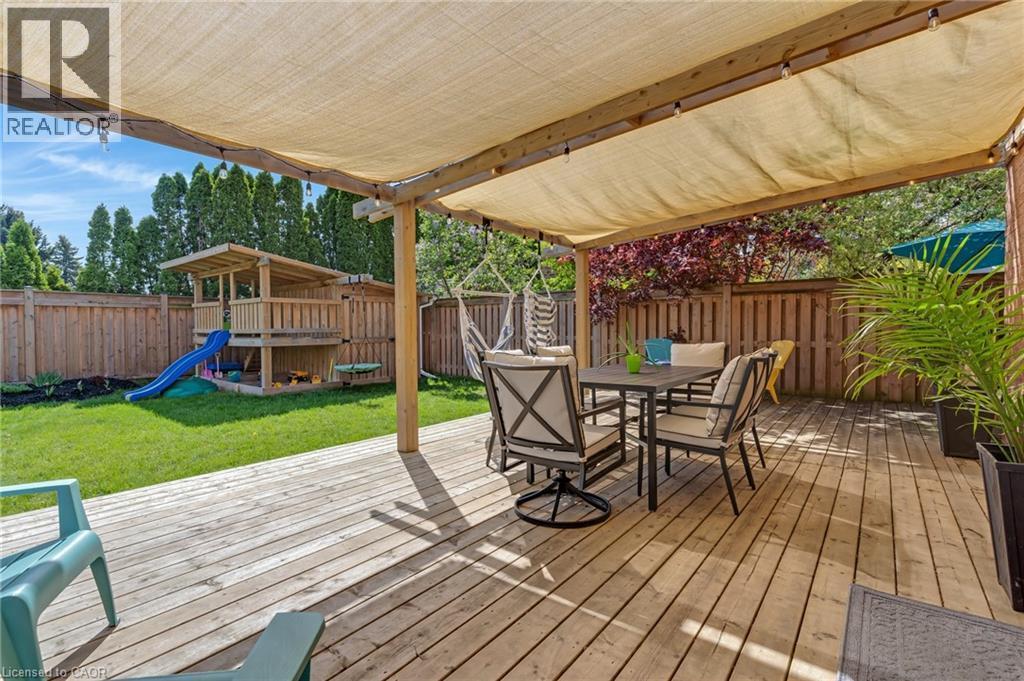 Expansive wood deck with a retractable shade canopy and string lighting - 42 Handorf Drive, Cambridge, ON - Outdoor With Deck Patio Veranda