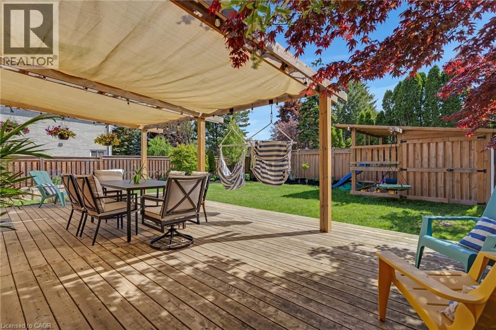 Spacious wooden deck featuring a retractable fabric awning, offering shade over an exterior dining area - 42 Handorf Drive, Cambridge, ON - Outdoor With Deck Patio Veranda