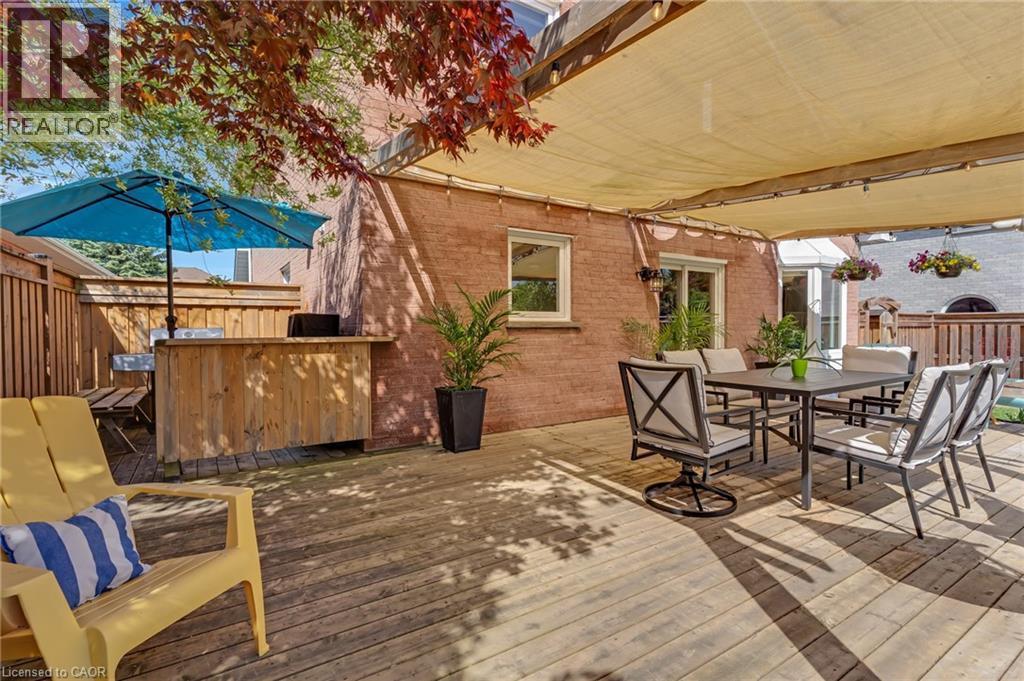 Expansive wood deck featuring a shade canopy, built-in wooden bar, and privacy fencing - 42 Handorf Drive, Cambridge, ON - Outdoor With Deck Patio Veranda With Exterior
