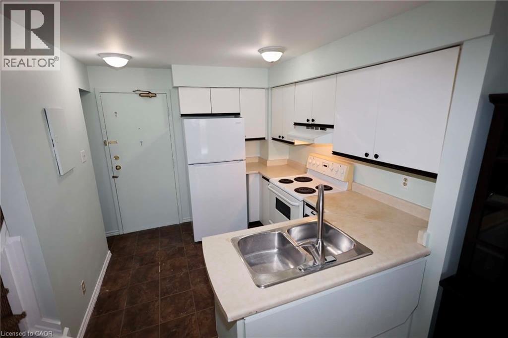 Compact kitchen featuring white cabinetry and appliances - 67 Valleyview Road Unit# 58, Kitchener, ON - Indoor Photo Showing Kitchen With Double Sink