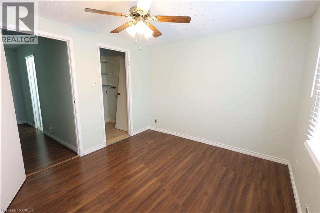 Bright room featuring wood-finish flooring, light-colored walls, white trim, a ceiling fan with light fixture, and a window with horizontal blinds - 67 Valleyview Road Unit# 58, Kitchener, ON - Indoor Photo Showing Other Room
