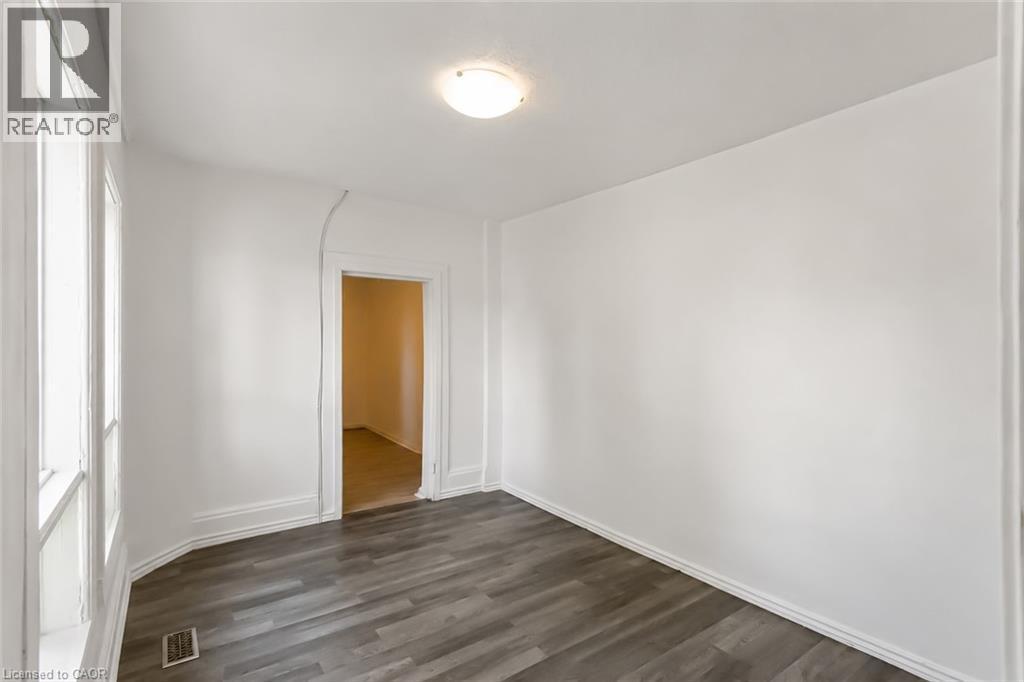 Room with wood-finish flooring, white walls, and a recessed doorway - 87 Lancaster Street W, Kitchener, ON - Indoor Photo Showing Other Room