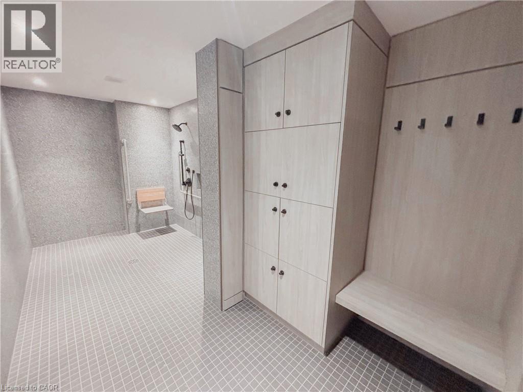 Spacious shower area featuring light grey textured wall tiles and small square floor tiles - 15 Wellington Street S Unit# 1909, Kitchener, ON - Indoor Photo Showing Other Room