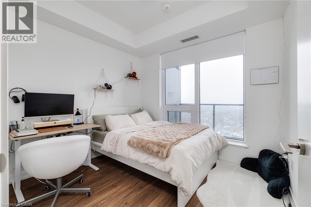 Bedroom with hardwood / wood-style floors and a tray ceiling - 15 Wellington Street S Unit# 1909, Kitchener, ON - Indoor Photo Showing Bedroom