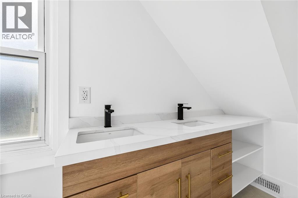 Full bathroom featuring double vanity, plenty of natural light, and lofted ceiling - 304 Park Street, Dundas, ON - Indoor