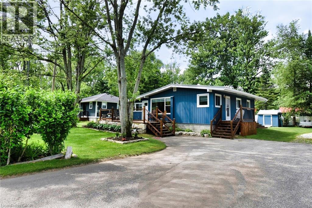 Blue exterior with white trim, featuring multiple entry points with wood stairs and railings - 5 Ralph Street, Turkey Point, ON - Outdoor