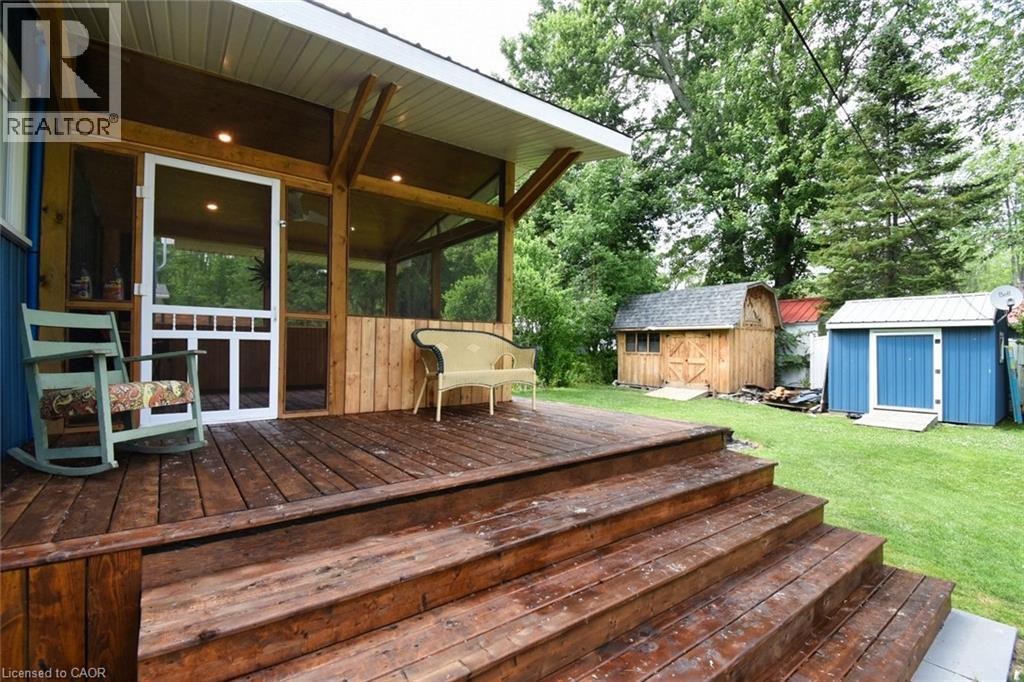 Expansive wooden deck with multi-level stairs leading to a screened-in porch with recessed lighting - 5 Ralph Street, Turkey Point, ON - Outdoor With Deck Patio Veranda