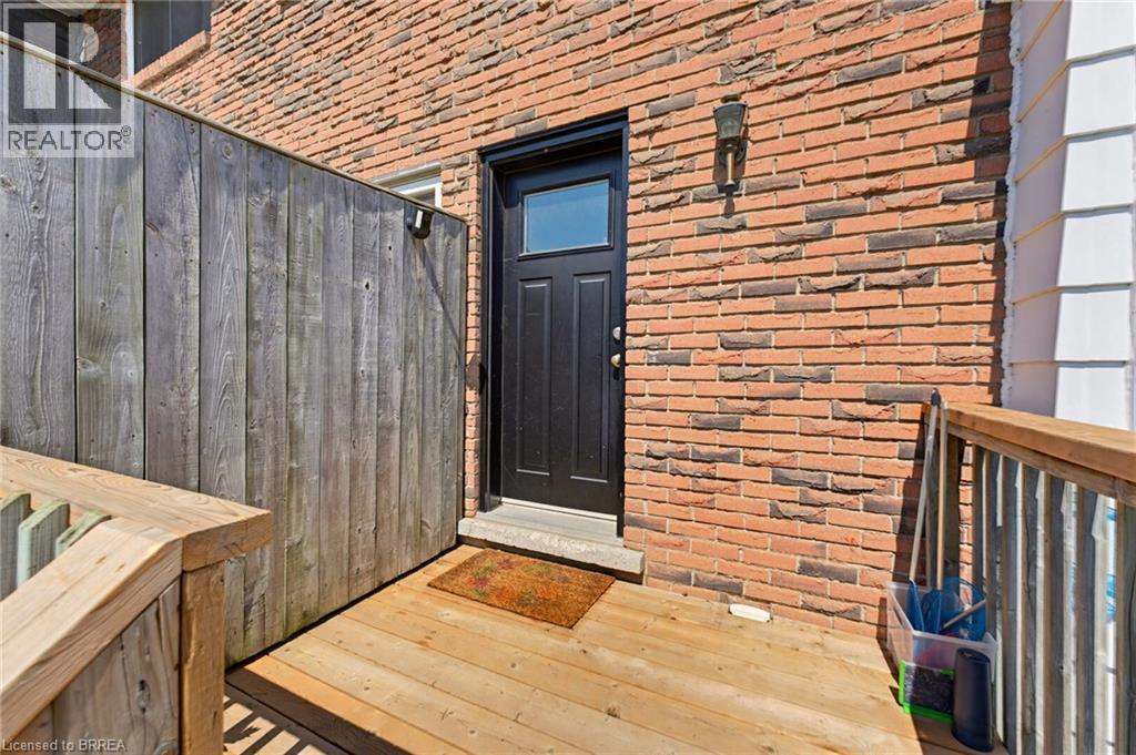 Exterior brick wall featuring an attached outdoor light fixture - 26 Coachwood Road Unit# 6, Brantford, ON - Outdoor With Exterior