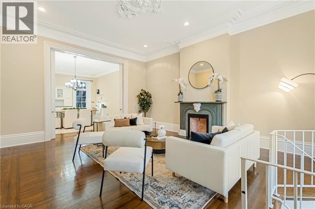 Living room featuring a chandelier, a fireplace, crown molding, recessed lighting, and wood finished floors - 46 Herkimer Street Unit# 2, Hamilton, ON - Indoor Photo Showing Living Room With Fireplace