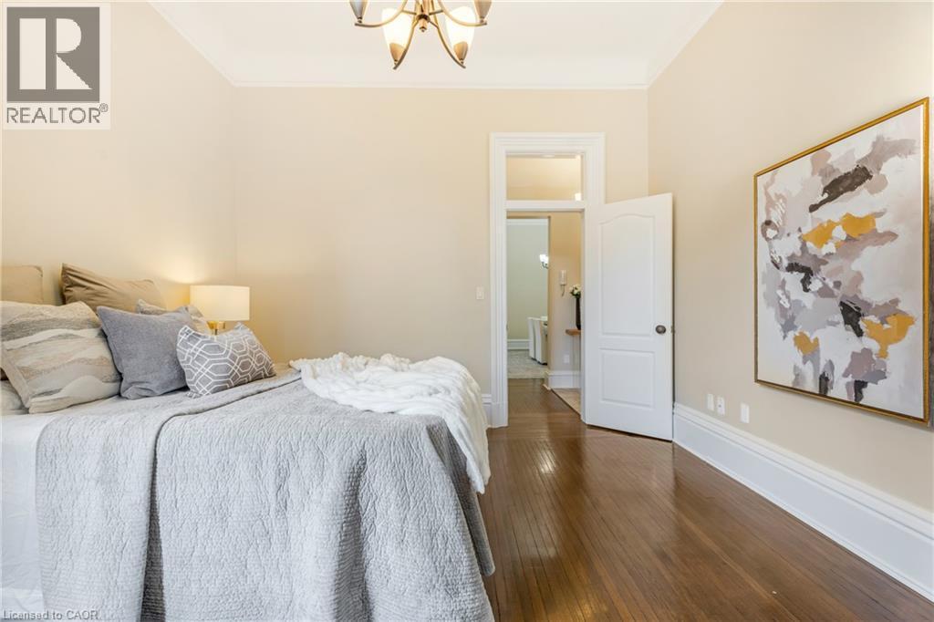 Bedroom featuring ornamental molding, dark wood-type flooring, and a chandelier - 46 Herkimer Street Unit# 2, Hamilton, ON - Indoor Photo Showing Bedroom