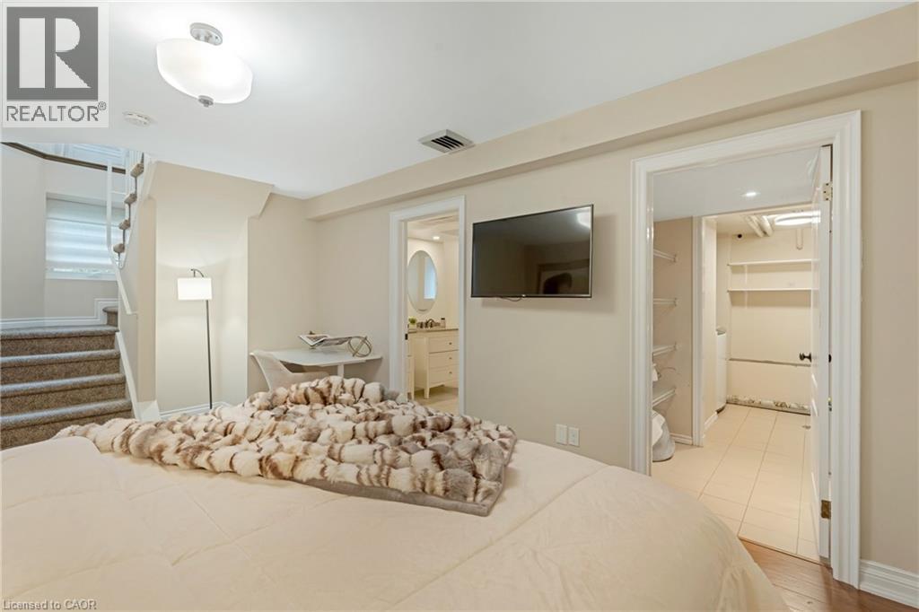 Bedroom featuring a spacious closet, ensuite bathroom, and light wood-style floors - 46 Herkimer Street Unit# 2, Hamilton, ON - Indoor Photo Showing Bedroom