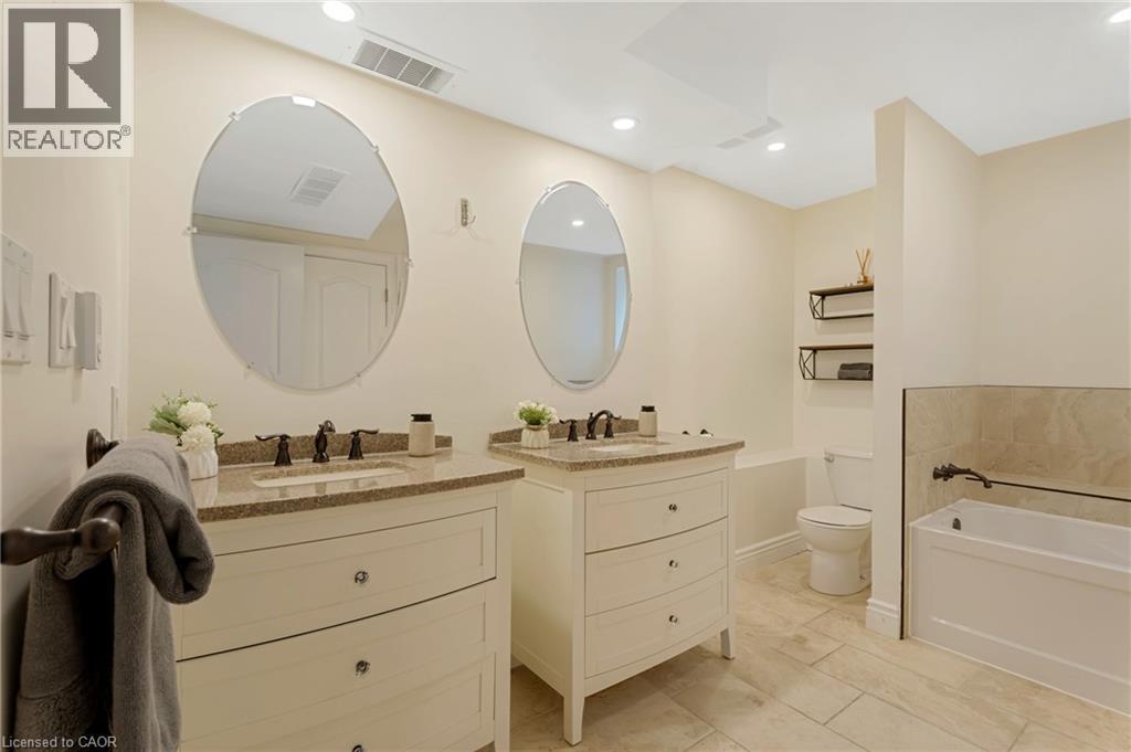 Full bath with two vanities, a bath, and recessed lighting - 46 Herkimer Street Unit# 2, Hamilton, ON - Indoor Photo Showing Bathroom