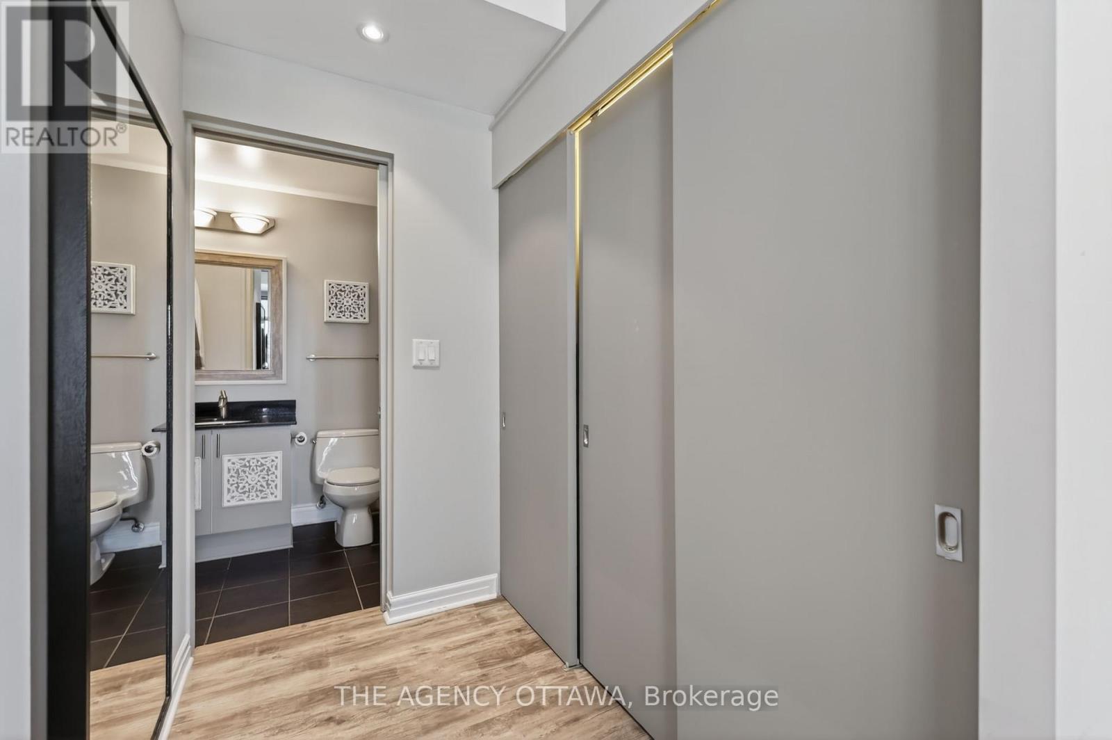 Hall to bathroom with mirrored closet doors - 905 - 85 Bronson Avenue, Ottawa, ON - Indoor