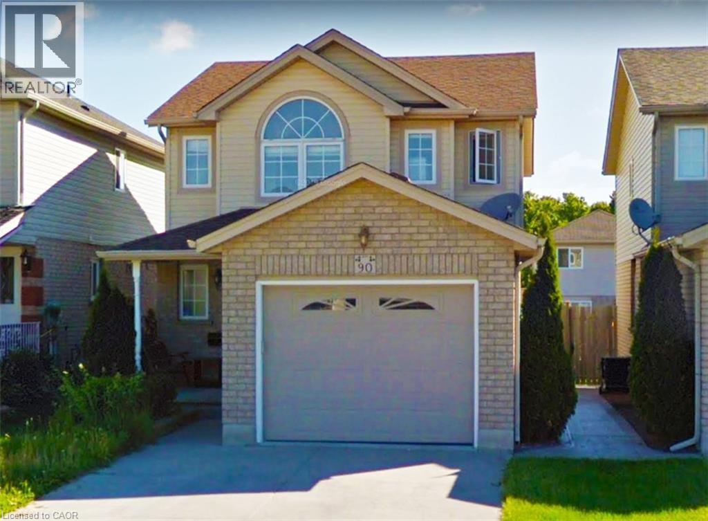 Two-story residence featuring a brick and siding exterior, an arched window, and an attached garage with a paved driveway - 90 Bridlewreath Street Unit# Upper Unit, Kitchener, ON - Outdoor