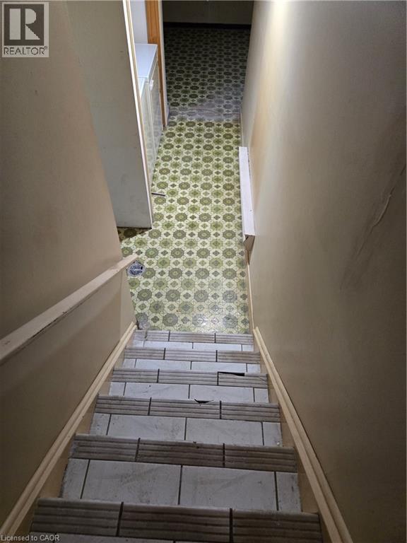 Staircase featuring tile treads and a wood handrail - 95 Fonthill Road Unit# 2, Hamilton, ON - Indoor Photo Showing Other Room
