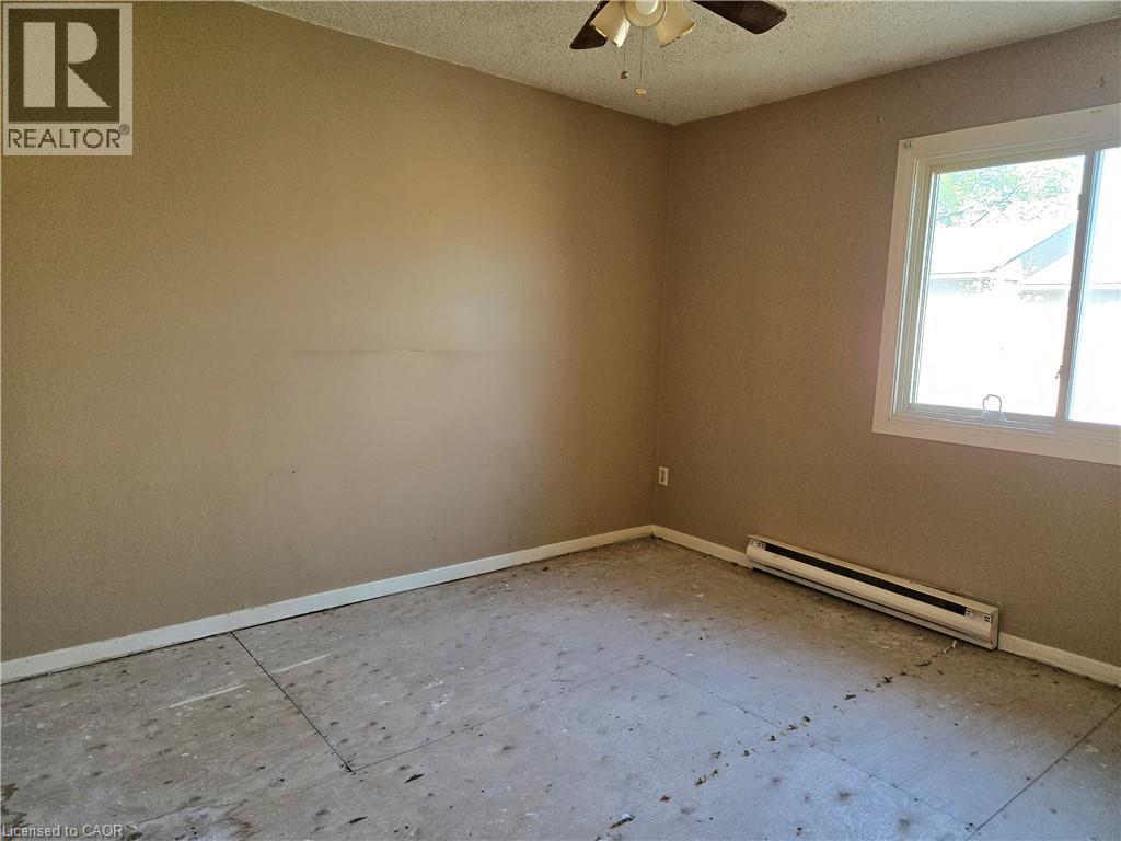 Room featuring a window with white trim, tan painted walls, and a ceiling fan with light fixture - 95 Fonthill Road Unit# 2, Hamilton, ON - Indoor Photo Showing Other Room