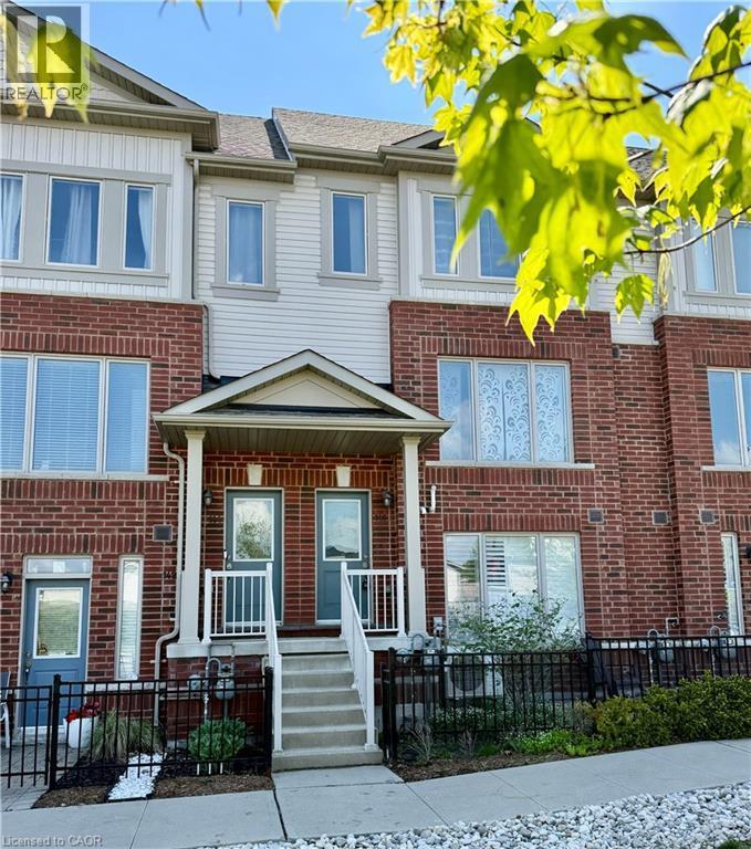 Multi-level townhome featuring brick and siding exterior, a covered porch entrance, and a black wrought iron fence - 146 Watson Parkway, Guelph, ON - Outdoor With Facade