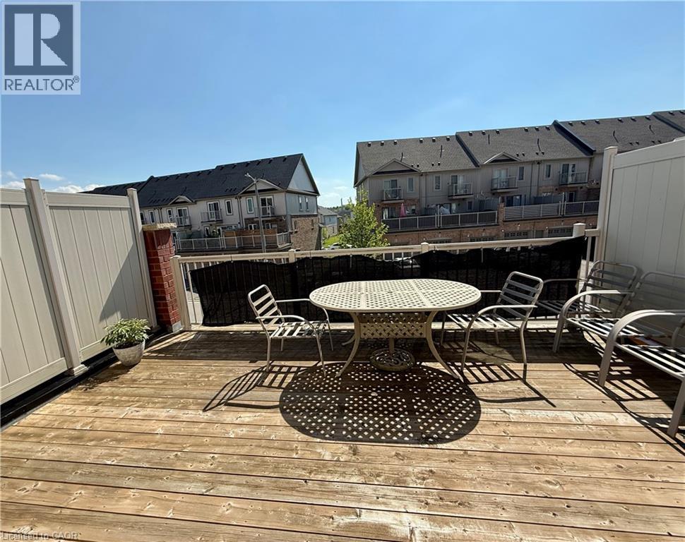 Expansive wood-finish deck with a privacy fence, brick pillar accent, and white railing - 146 Watson Parkway, Guelph, ON - Outdoor With Deck Patio Veranda With Exterior