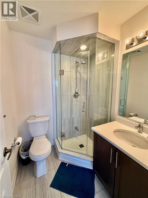 Corner glass-enclosed shower with tile surround, white tile shower pan, and chrome fixtures - 146 Watson Parkway, Guelph, ON - Indoor Photo Showing Bathroom