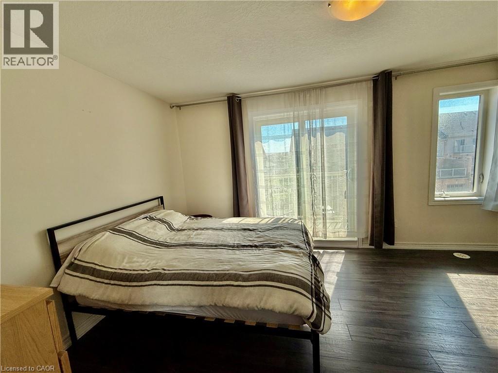 Spacious room featuring wood-finish flooring, light-toned walls, and a ceiling-mounted light fixture - 146 Watson Parkway, Guelph, ON - Indoor Photo Showing Bedroom