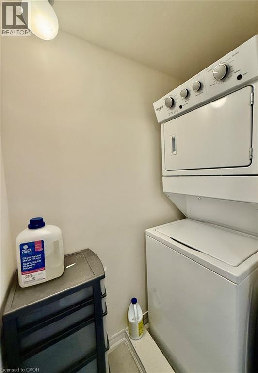 Dedicated laundry space featuring a stacked washer and dryer unit - 146 Watson Parkway, Guelph, ON - Indoor Photo Showing Laundry Room