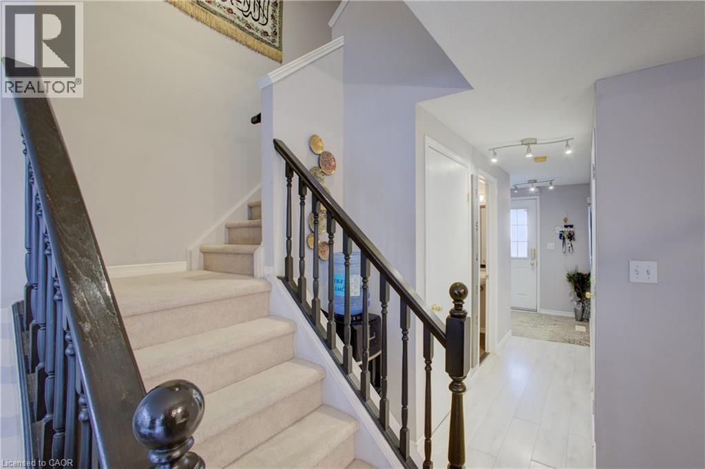 Carpeted staircase with dark wood banister and spindles - 53 Prosperity Drive, Kitchener, ON - Indoor Photo Showing Other Room