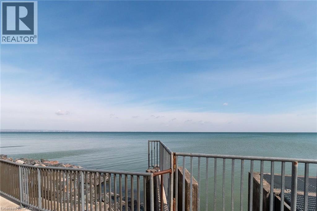 Waterfront property featuring a metal railing system, concrete walkway, and a natural rock shoreline - 500 Green Road Unit# 901, Stoney Creek, ON - Outdoor With Body Of Water With Balcony