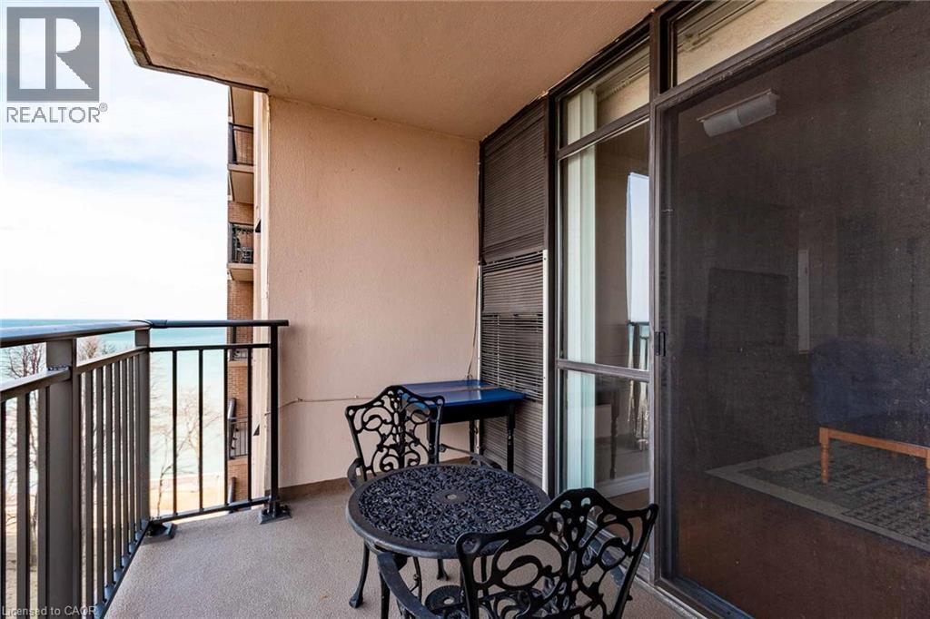Outdoor balcony featuring a painted concrete floor, black metal railings, and a full-height sliding glass door - 500 Green Road Unit# 901, Stoney Creek, ON - Outdoor With Balcony With Exterior