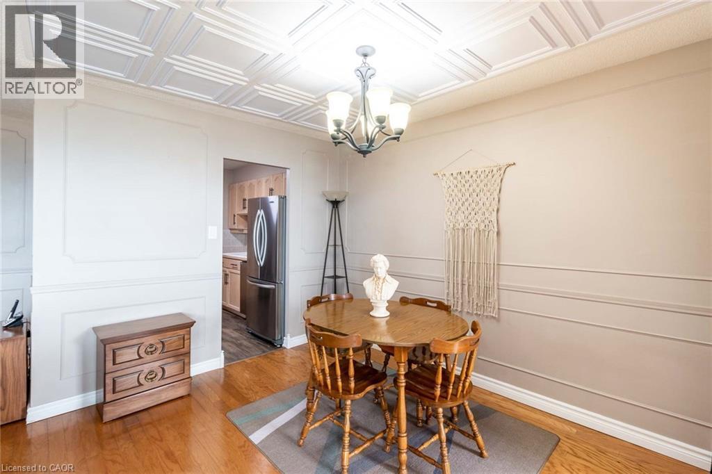 Dining area featuring a coffered ceiling, hardwood flooring, and decorative wall molding - 500 Green Road Unit# 901, Stoney Creek, ON - Indoor Photo Showing Dining Room