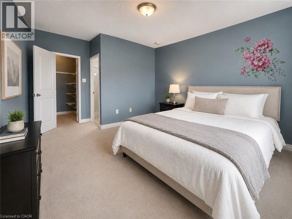 Plush carpeted flooring and light blue wall tones define this bedroom space - 255 Keats Way Unit# 606, Waterloo, ON - Indoor Photo Showing Bedroom