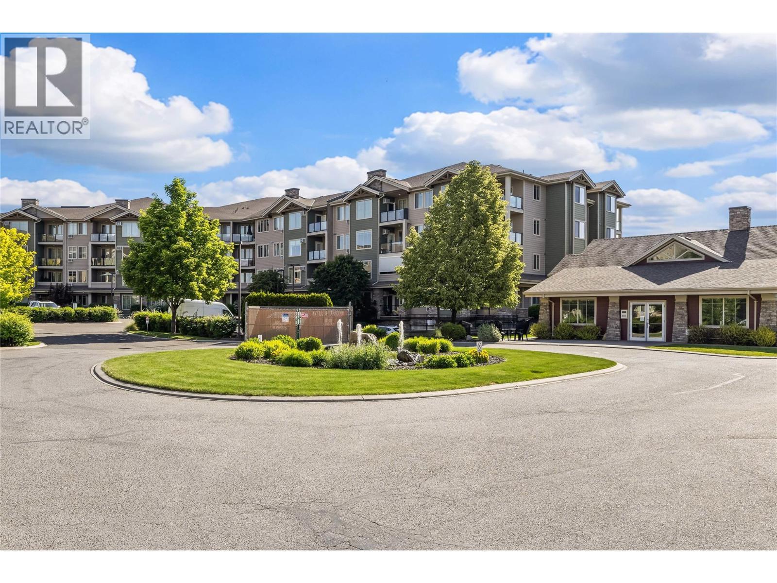 Beautifully Landscaped, Fountain and Clubhouse - 3735 Casorso Road Unit# 410, Kelowna, BC - Outdoor With Facade