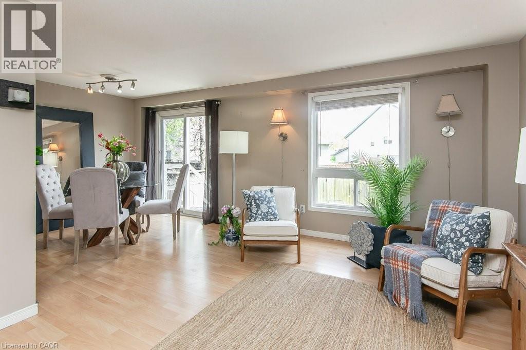 Open concept living area featuring light wood-finish flooring, a dining space with track lighting, and a sliding glass door - 71 Foxglove Crescent, Kitchener, ON - Indoor