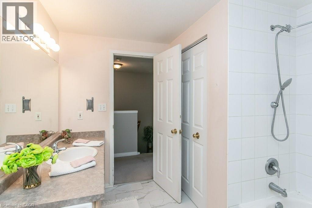 Bathroom featuring a vanity with an integrated sink, a large wall mirror, and a multi-bulb light fixture - 71 Foxglove Crescent, Kitchener, ON - Indoor Photo Showing Bathroom