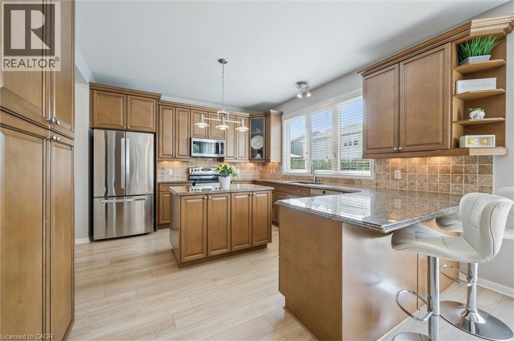 Large Kitchen with granite countertops, under-cabinet lighting, breakfast bar and island with plenty of storage space. Garage entry to the left - 79 Zieman Crescent, Cambridge, ON - Indoor Photo Showing Kitchen With Stainless Steel Kitchen