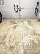 Dedicated parking space featuring concrete flooring, a concrete wall, and two electric vehicle charging stations with associated conduit -