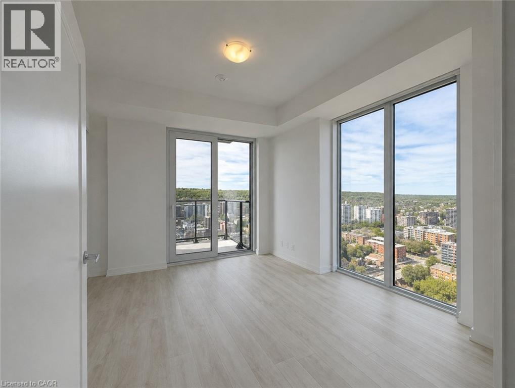 Spacious room featuring floor-to-ceiling windows and a sliding glass door leading to a balcony - 75 James Street S Unit# 2614, Hamilton, ON - Indoor