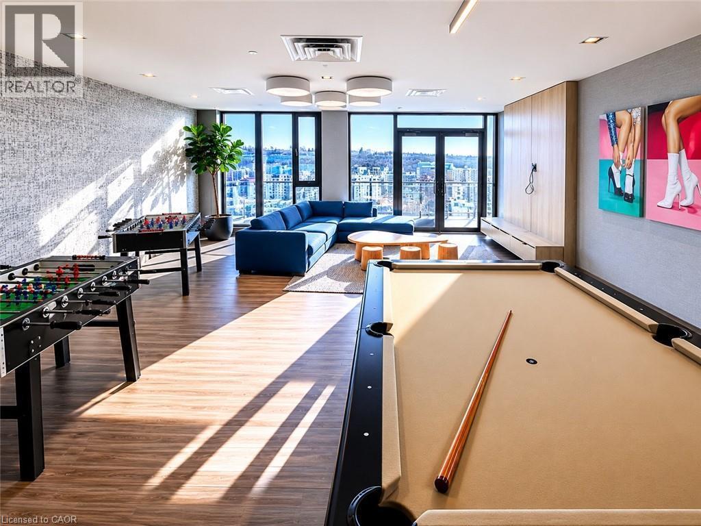 Spacious recreational room featuring wood-finish flooring and large windows - 75 James Street S Unit# 2614, Hamilton, ON - Indoor Photo Showing Other Room
