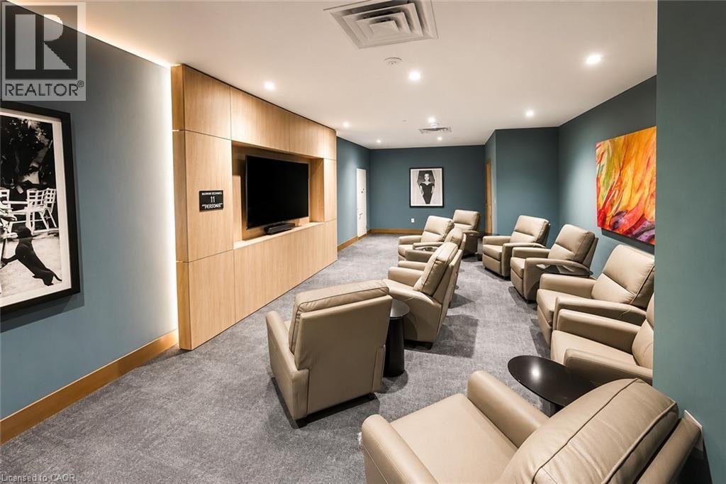 Dedicated media room featuring a large television display within a light wood-finish media console - 75 James Street S Unit# 2614, Hamilton, ON - Indoor Photo Showing Other Room