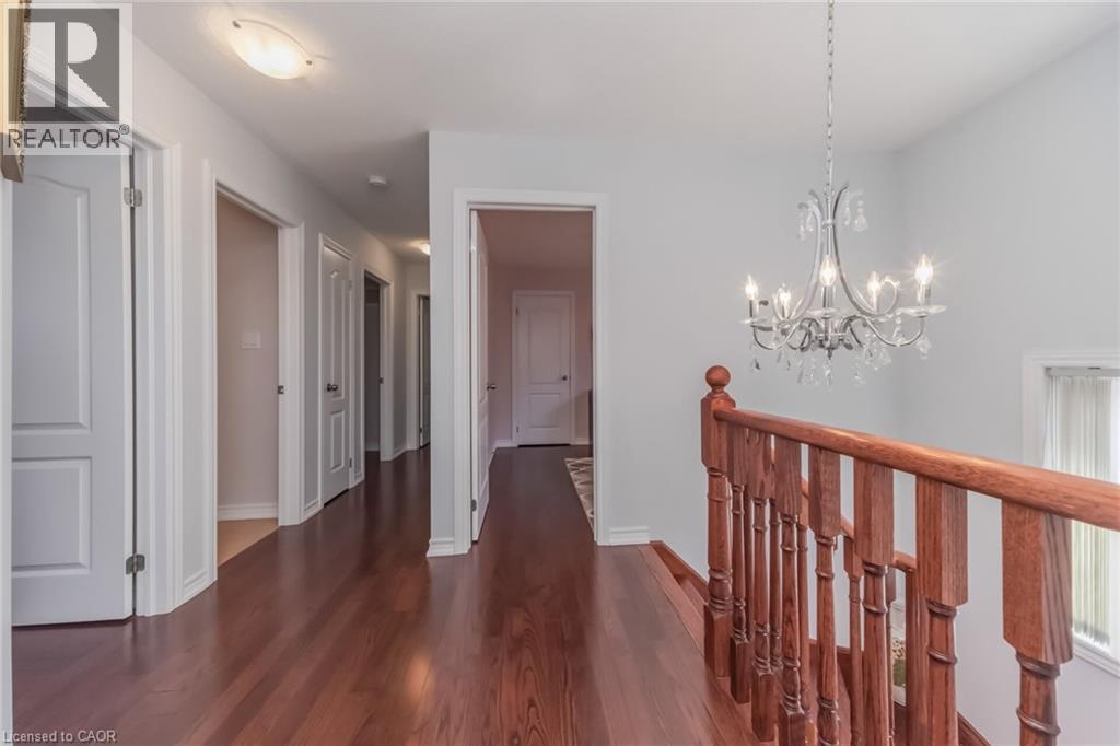 Hallway featuring wood-finish flooring, white doors, and light gray wall paint - 675 Best Road, Milton, ON - Indoor Photo Showing Other Room