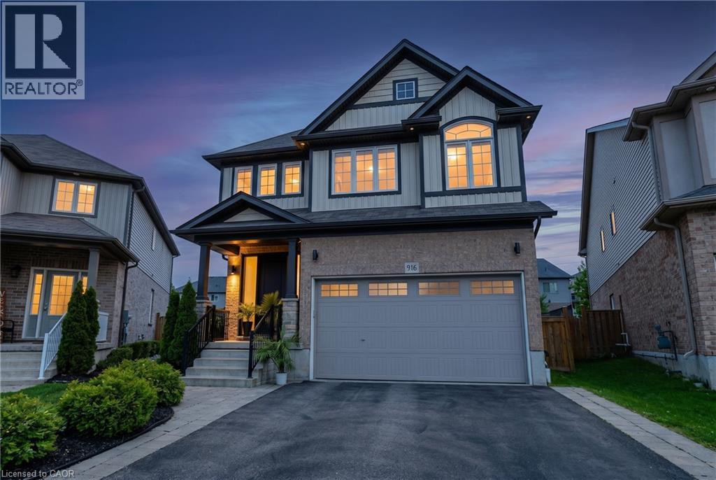 Two-story residence featuring a brick and siding exterior, an attached two-car garage, and a covered front porch with stone pillars - 916 Steepleridge Court, Kitchener, ON - Outdoor With Facade