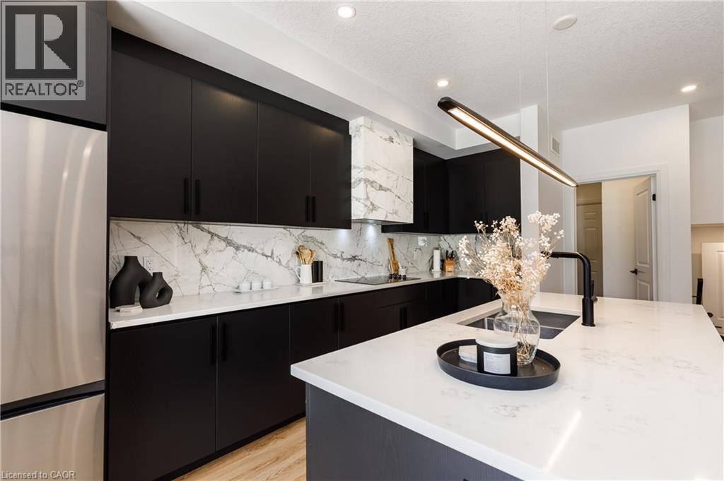 Kitchen featuring dark cabinetry, white countertops, stainless steel appliances, a white marble-patterned backsplash, and recessed lighting - 916 Steepleridge Court, Kitchener, ON - Indoor Photo Showing Kitchen With Upgraded Kitchen