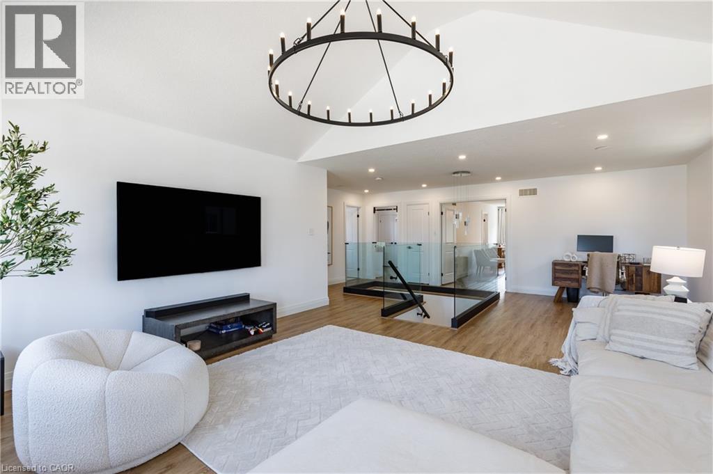 Vaulted ceiling with a large circular chandelier - 916 Steepleridge Court, Kitchener, ON - Indoor Photo Showing Living Room