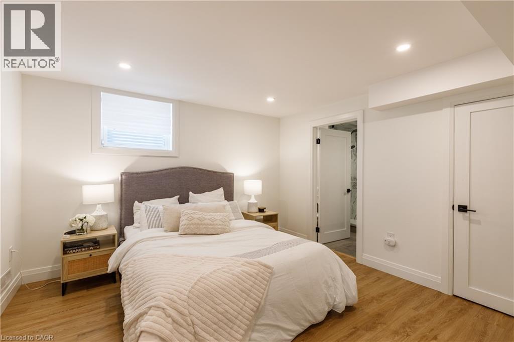 Bright interior featuring wood-finish flooring, recessed lighting, and white walls - 916 Steepleridge Court, Kitchener, ON - Indoor Photo Showing Bedroom