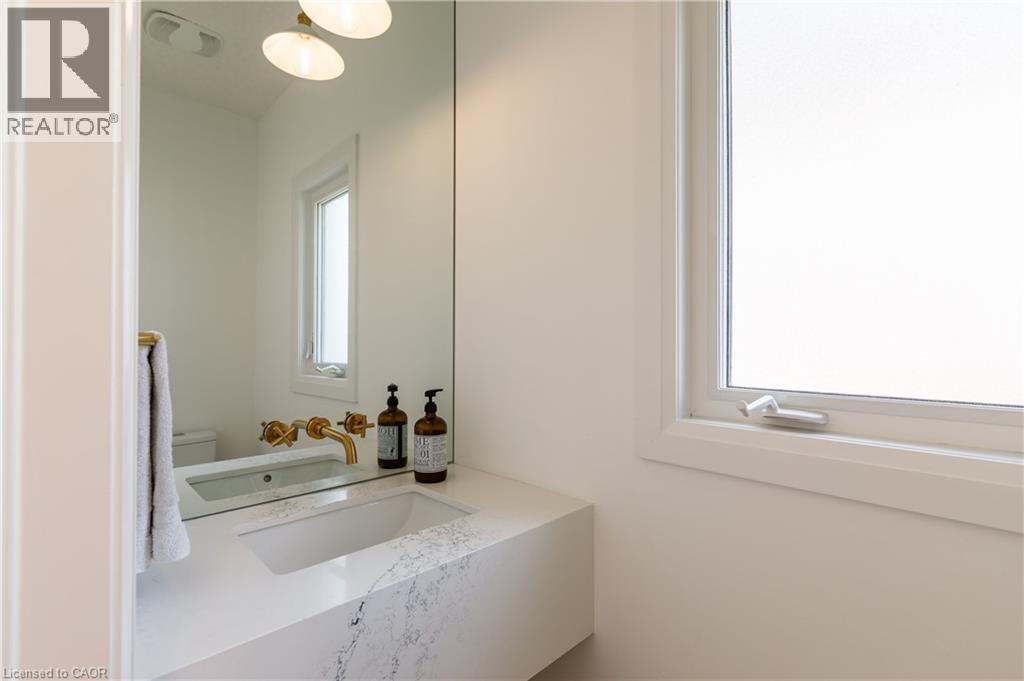 Floating vanity with an integrated sink and veined stone-finish countertop - 916 Steepleridge Court, Kitchener, ON - Indoor Photo Showing Bathroom