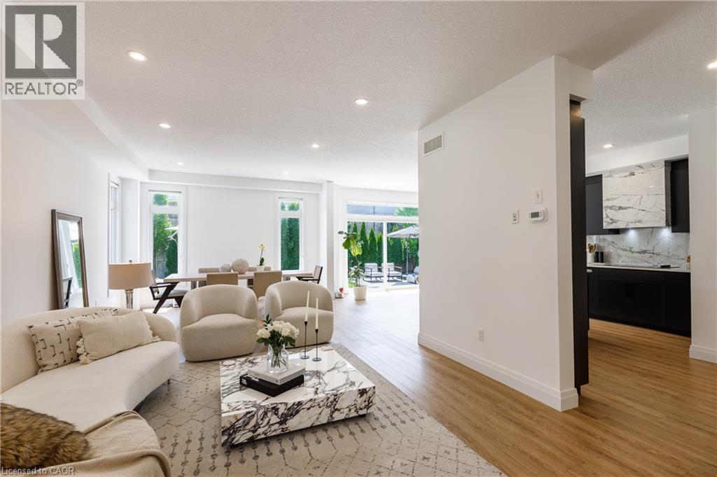Open-concept main living area with wood-finish flooring, recessed lighting, and expansive windows - 916 Steepleridge Court, Kitchener, ON - Indoor Photo Showing Living Room