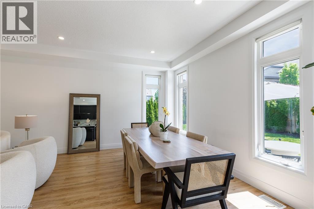 Bright dining area featuring wood-finish flooring, recessed lighting, and multiple windows - 916 Steepleridge Court, Kitchener, ON - Indoor Photo Showing Dining Room