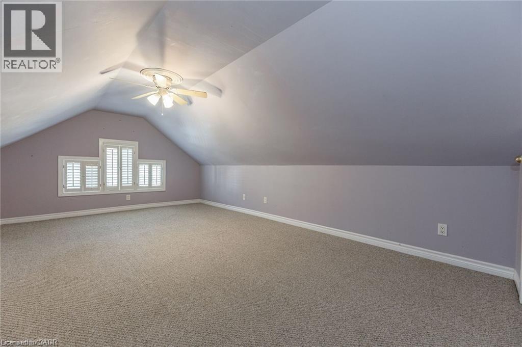 Spacious room featuring sloped ceilings, light-toned carpeting, and white baseboards - 252 Beechwood Avenue, Hamilton, ON - Indoor Photo Showing Other Room